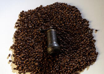 Old coffee grinder with coffee beans in the background