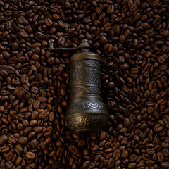 Old coffee grinder with coffee beans in the background