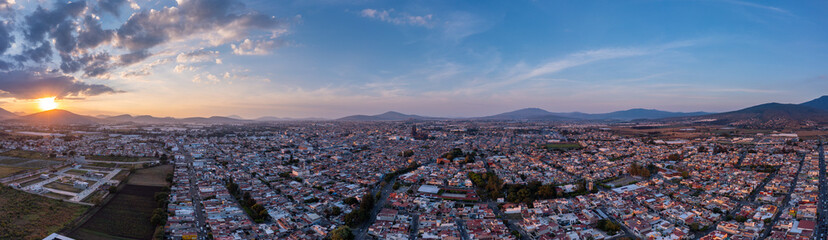Fototapeta na wymiar Aerial: spectacular sunset in the mountains and cityscape. Drone view