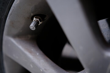 Air valve of a car tire close-up.