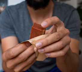 Man unwrapping guava paste snack in plantain leaves   © Eric Gomez