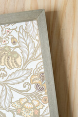 wood frame with decorative scrapbook paper on wooden surface