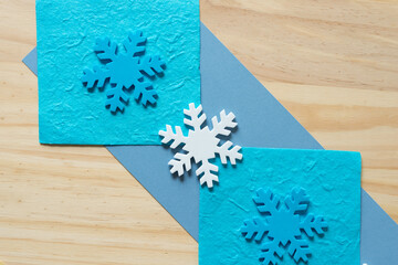 Christmas themed background with snowflakes and paper on wood