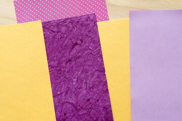 mostly yellow and purple paper and wood background