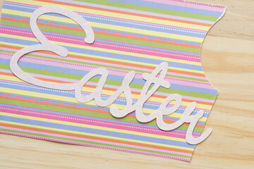 Easter message on paper with stripes and wood