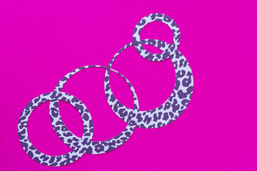 fancy paper rings on pink paper with embossed pattern