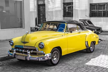 Fototapeten colorkey of yellow convertible classic car on the street of havana cuba © Michael Barkmann