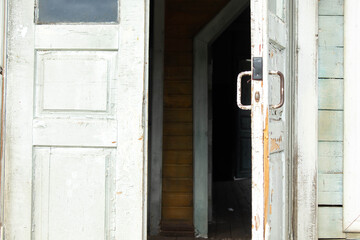 a person opens an old wooden door with a latch