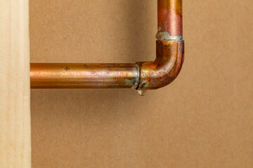 Copper plumbing pipe leaking water inside wall. Home repair, maintenance and remodeling concept. - obrazy, fototapety, plakaty