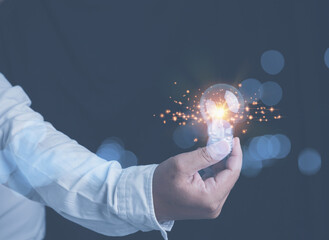 Businessman holding a bright illuminated light bulb on hand with copy space. Ideas innovation technology of future. Inspiration idea of business for growth to the future.