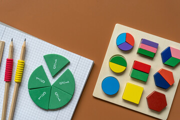 Set of supplies for mathematics and for school. Fractions, rulers, pencils, notepad on brown...
