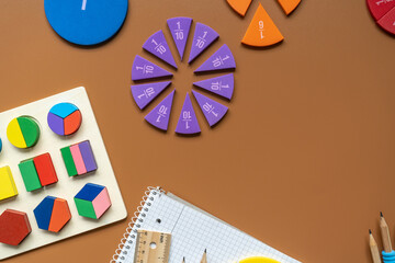Set of supplies for mathematics and for school. Fractions, rulers, pencils, notepad on brown...