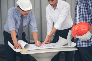 Civil Construction engineer teams shaking hands together wear work helmets worker on construction site. Foreman industry project working engineer teamwork. Two asian engineer team shake hands together