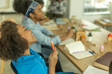 A learner center class of young African kids working on their project with fun and enjoyment. Kids support each other to learn in friendly atmosphere. An interactive class for young pupil
