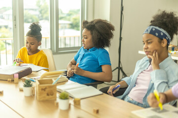 Fototapeta premium A learner center class of young African kids working on their project with fun and enjoyment. Kids support each other to learn in friendly atmosphere. An interactive class for young pupil