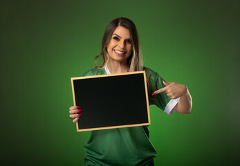 woman soccer fan cheering for her favorite club and team. world cup green background. Holding a blackboard.