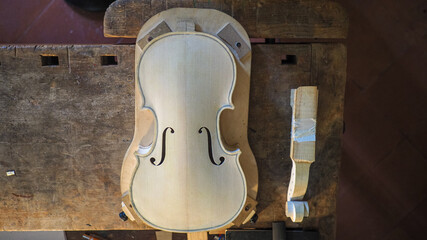 handmade blank violin ready to be varnished at luthier desk