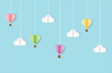 Colorful hot air balloons with white clouds on pastel blue background of various shapes for decoration in the celebration party.