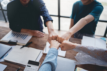 Business team unity. Group of colleagues from various parties join hands during a company meeting in the office. Diverse colleagues celebrate successful teamwork.