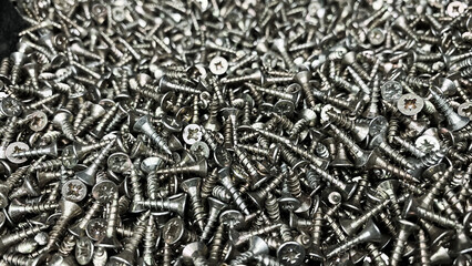Shiny short self-tapping screws close-up. Warehouse of small parts for the assembly of various...