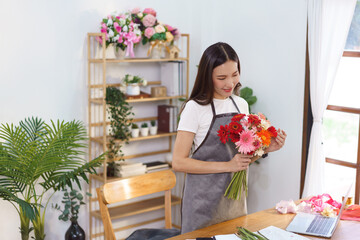 Flower shop concept, Female florist holding colorful gerbera to prepare for making flower bouquets