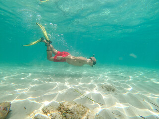 underwater man snorkeling in the sea withcrystal-clear waters of a beach concept of holiday relax...