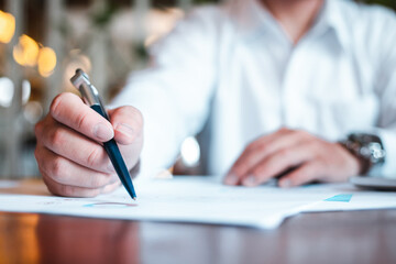 Hand businessman signing contract. Asia businessman check the correctness of work at the office with a beautiful pen. Hands working with documents at desk and signing contract.Deal concept.