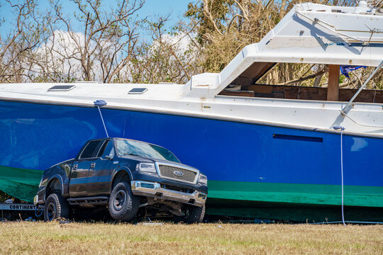 Photo of a boat pinning down a pick up truck after Hurricane Ian storm surge aftermath