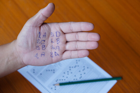 Closeup hand with written numbers and letters .Student write answer on palm.Concept : cheat the test. Dishonest behaviour. Education assessment.   