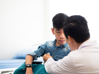 Asian professional doctor listening heart rate pulse young boy patient by stethoscope equipment in appointment room at clinic