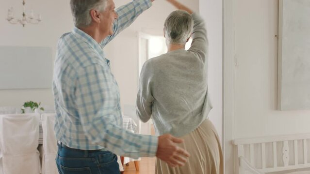 Retirement couple dancing in home with happiness for real estate investment or mortgage on their dream property house. Dance, love and happy marriage senior pension man and woman in their living room