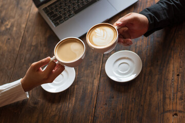  Male and female employees clink coffee cups to celebrate at the office cafe Chiang Mai 29.92.2022