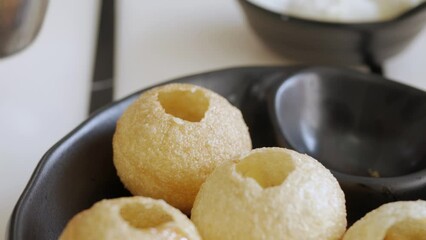 put sauce and picking crunchy homemade Golgappa Panipuri traditional indian tasty snacks Street food. Delicious Panipuris.