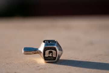 A small silver cast dreidel top used during a game played on Hanukkah, the Jewish festival of lights.