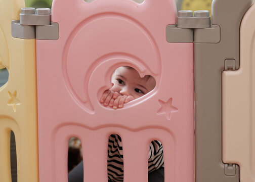 a boy is looking through an opening of his playpan