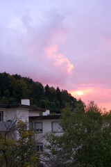 Beautiful autumn evening sky at City of Z&uuml;rich with red, orange and yellow colored clouds and facade of apartment house in the foreground. Photo taken September 30th, 2022, Zurich, Switzerland.