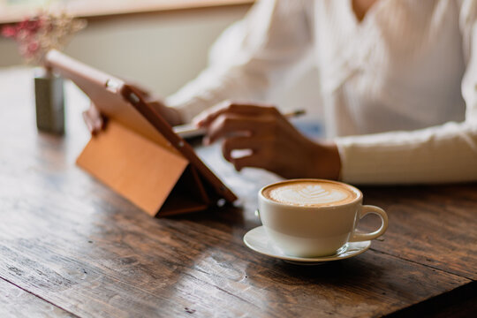 White Hot Coffee A Woman In A White Shirt Works An Orange IPad At A Coffee Shop In Chiang Mai On 29.9.2022.