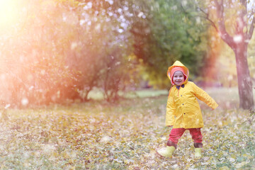 A child in a raincoat for a walk outside in autumn