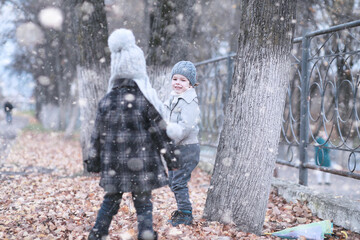 Naklejka premium Kids walk in the park first snow
