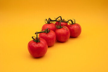 Fresh Red Tomatoes on a Bright Yellow Background