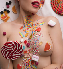Nude blonde body covered with sweets and caramel