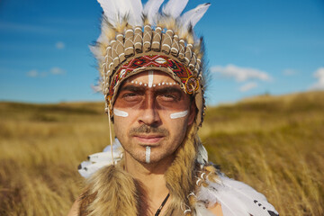 A man in traditional Native American clothing in the steppe