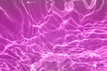 Defocus blurred transparent pink colored clear calm water surface texture with splashes and bubbles. Trendy abstract nature background. Water waves in sunlight with copy space. Pink watercolor shining