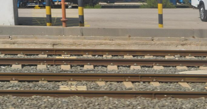 Railes de tres en marcha vista desde la ventana cerca de una estaci&oacute;n