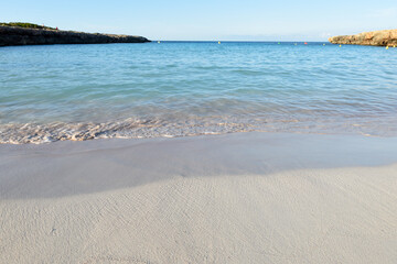 Beautiful view of clear water at the shore of the sea on a sandy beach