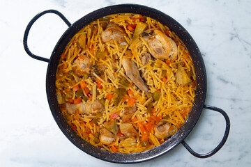 Paella with noodles, rabbit and vegetables. Tapa typical of the Spanish coast.