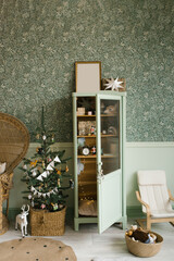 Scandinavian mint Christmas interior with decorated Christmas tree in children's room. Wardrobe with children's toys, wicker chair, chest of drawers © Sunshine