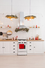 Interior of a light white kitchen with bright red decor elements in the Scandinavian style, decorated for Christmas