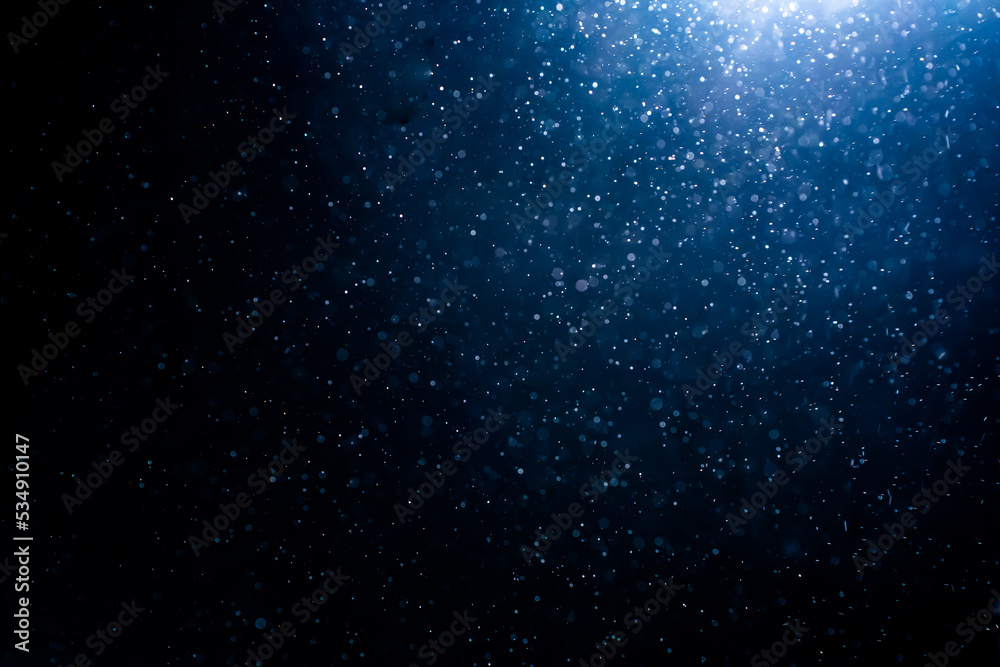 Wall mural blue particles on black background with cinematic atmosphere. glittering sparkling bokeh overlay wit
