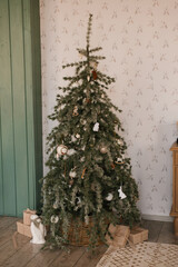 Stylish Christmas tree with toys in the children's room and gifts under it